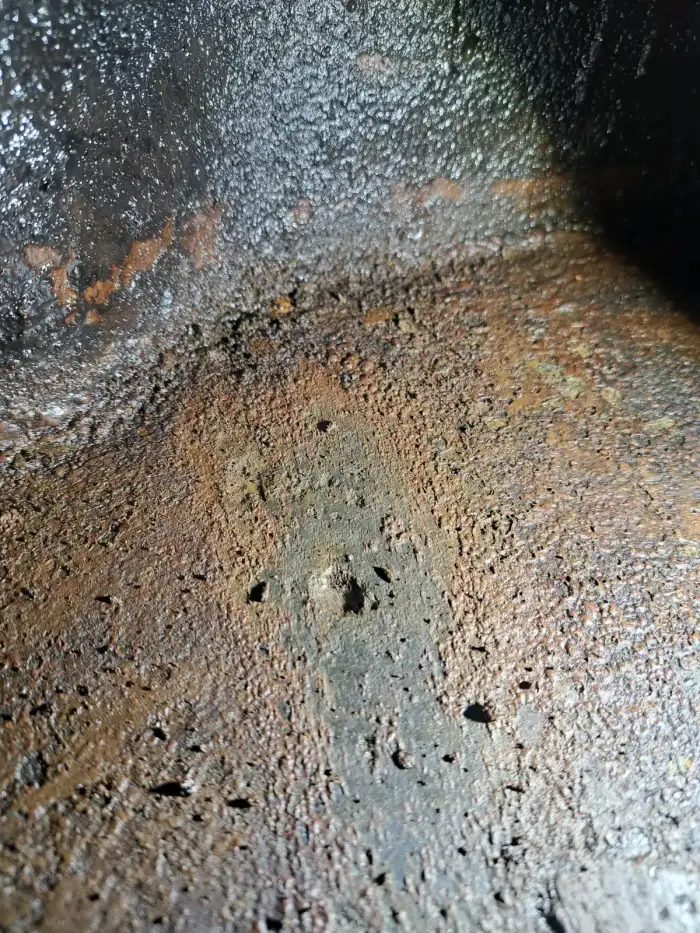 Nahaufnahme Roststruktur am Tankboden — körnige Ablagerungen als Zeichen fortgeschrittener Korrosion
