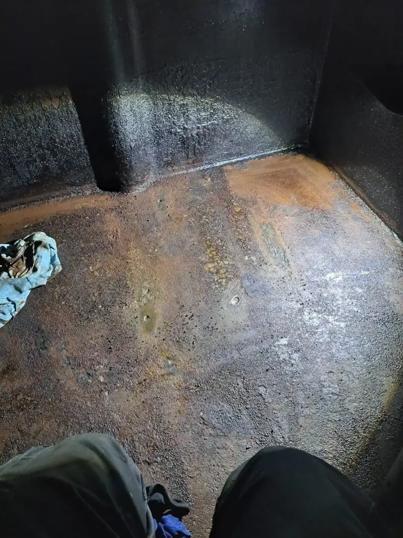 Blick in den Tankboden eines Stahltanks — weitflächige Korrosionsschäden am gesamten Boden sichtbar